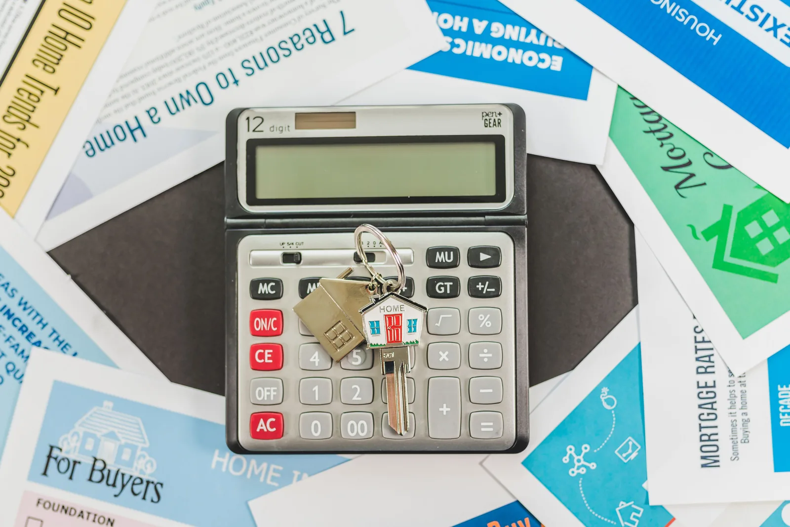 Calculator, house keys, and homebuying paperwork used to plan a mortgage budget