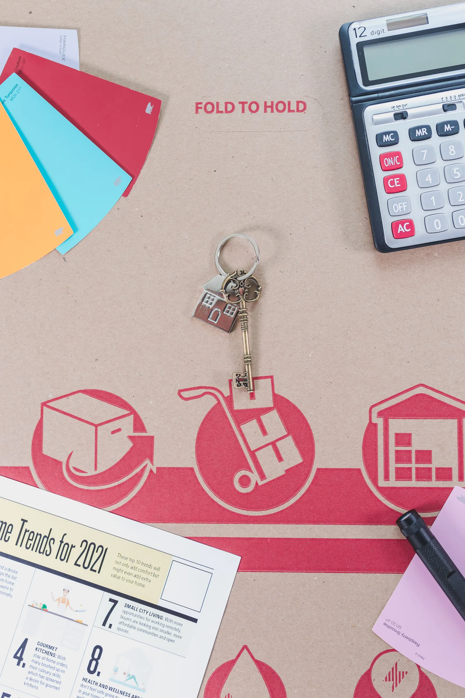Calculator, house key, and paperwork used to compare mortgage payment options