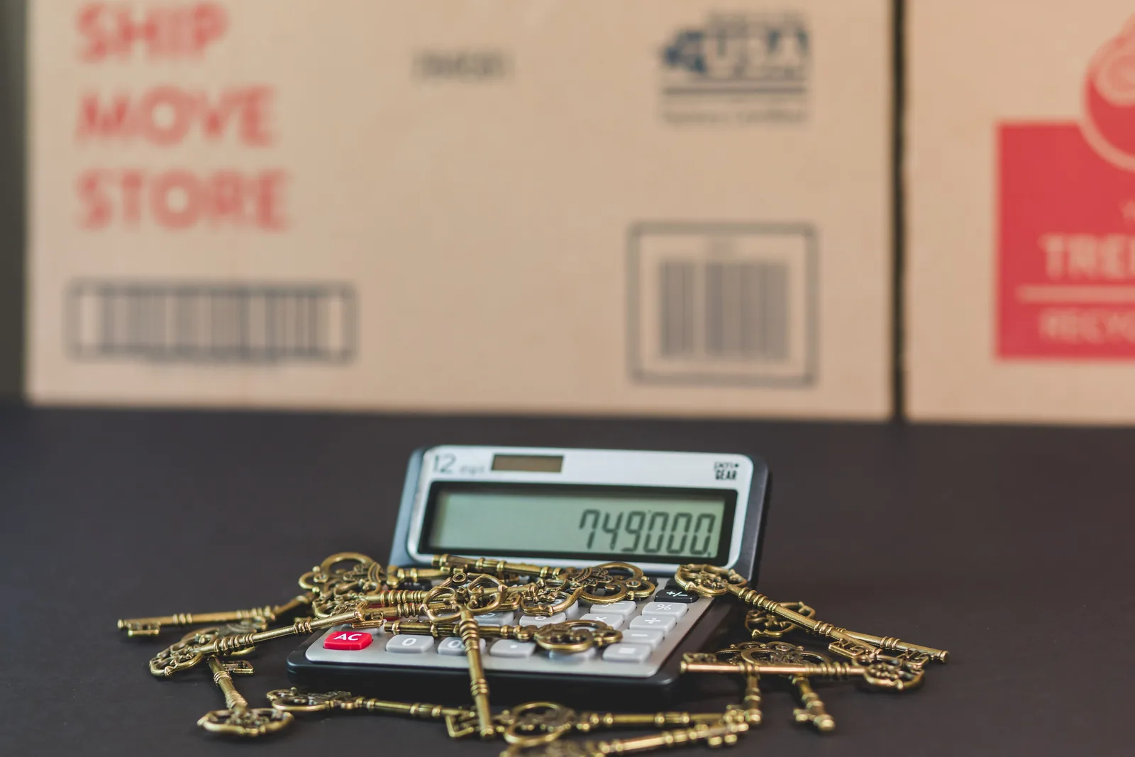 House keys resting on a calculator for a mortgage recast or refinance comparison